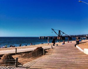 Valparaiso, Chile - 13 November 2014 : Valparaiso his recreational city beach is in the middle of a industrial harbor with cranes and containers around